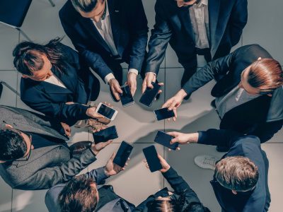 from the top view. business team uses their smartphones to work with financial data.